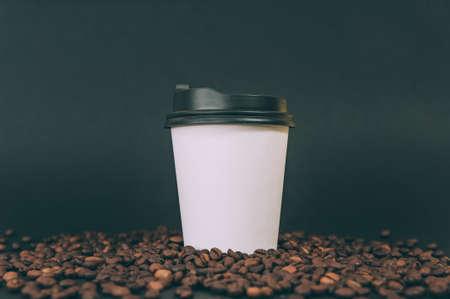 Disposable coffee glass on a background with coffee beansの写真素材