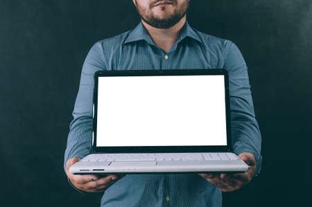 A man with a laptop in his hands on a dark background. Mockup technology