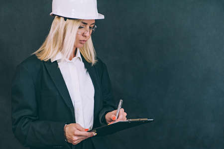 Businesswoman with documents in hands and a construction helmet on his headの写真素材