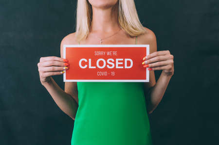 A girl in a green dress holds a tablet in her hands. Sorry We're Closed COVID-19の写真素材