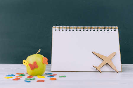 Mockup Back to School. Green apple with colored letters and notepad backgroundの写真素材