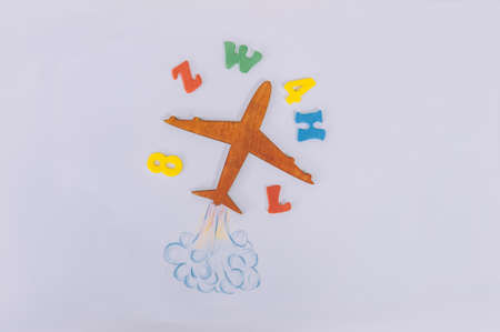 Concept Back to School. Flight of knowledge with airplane and colored letters on the backgroundの写真素材