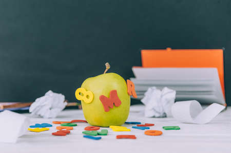 Concept Back to School. Green apple with colored letters and notepad backgroundの写真素材