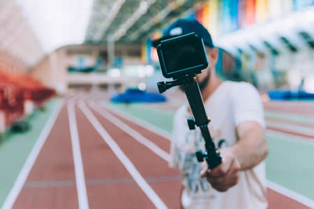 Blogger in the stadium shoots video with action cameraの写真素材