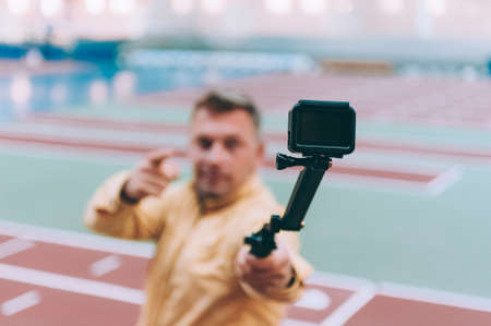 Blogger in the stadium shoots video with action cameraの写真素材
