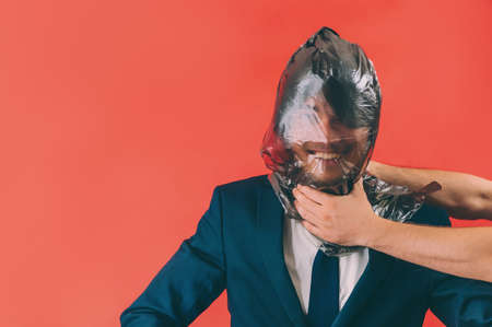 Businessman with a package on his head on a red background