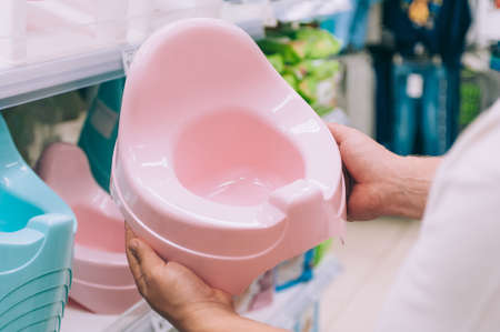 A guy chooses a potty for a baby in a storeの写真素材