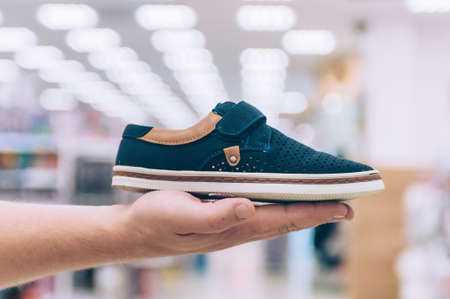 Man holds sneakers in his hand in a supermarketの写真素材
