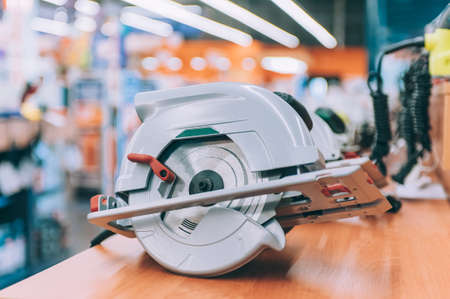 A hand-held cutting saw on a shelf with tools