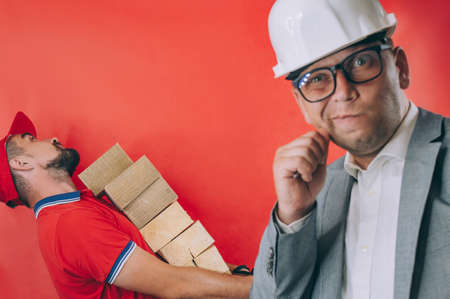 Chief and worker. Concept on a red backgroundの写真素材