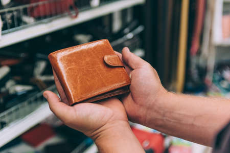 A man chooses a wallet in the store, in the background the counterの写真素材