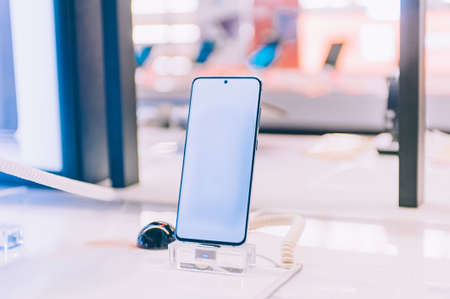 Mockup of a smartphone with a white screen on a supermarket showcaseの写真素材