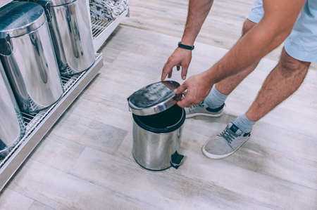 A shopper selects a trash can in a supermarketの写真素材