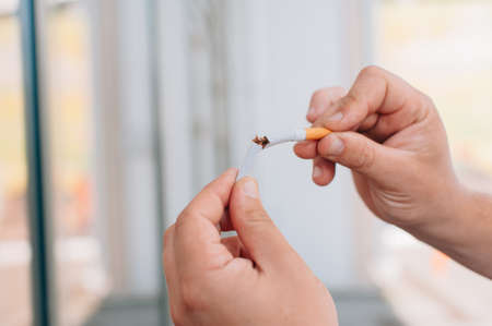 A guy with a cigarette in his handsの写真素材