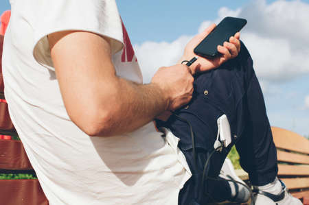 Portable charger in the hands of a person. Powerbank charges the phoneの写真素材
