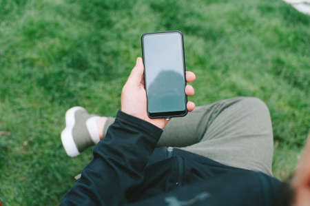 Mock-up technology. Man holds a smartphone in his hands close-upの写真素材