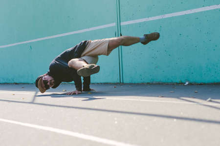 Bboy dancing breakdance against a blue wallの写真素材