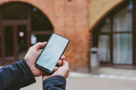 Mock-up technology. Man holds a smartphone in his hands close-upの写真素材