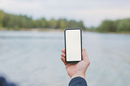 Mock-up technology. Man holds a smartphone in his hands close-upの写真素材