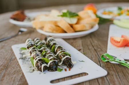 Fresh vegetables with salad and grilled sausages on a wooden table backgroundの写真素材