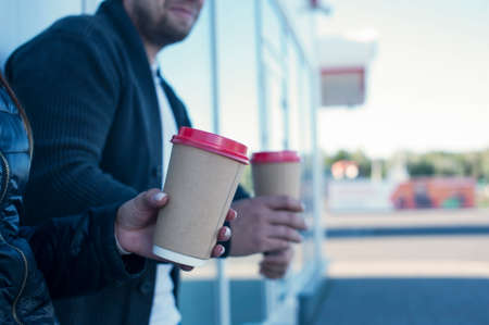 A girl and a guy are drinking coffee with a glass in their handsの写真素材