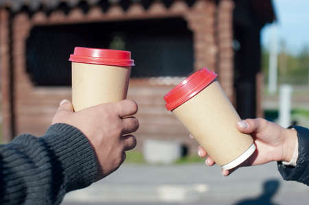 A girl and a guy are drinking coffee with a glass in their handsの写真素材
