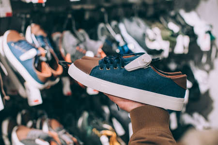 The guy holds in his hands sneakers in the supermarketの写真素材