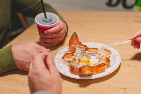 The guy and the girl eat pizza and drink a drinkの写真素材