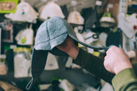 A man chooses a hat for a bath in the storeの写真素材