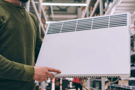 A man chooses a heater in a supermarketの写真素材