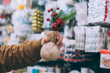 A man in a supermarket holds decorative holiday decorations in his handsの写真素材
