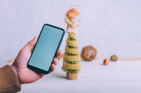Mockup technology. The guy holds a smartphone in his hands on a festive backgroundの写真素材