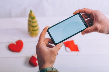 Mockup technology. The guy holds a smartphone in his hands on a festive backgroundの写真素材