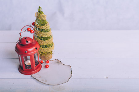 Festive composition for new year and christmas. Christmas tree with decoration and lamp on a white tableの写真素材