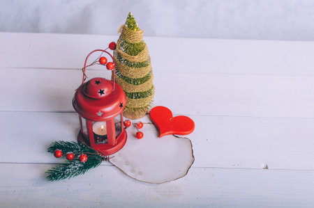 Festive composition for new year and christmas. Christmas tree with decoration and lamp on a white tableの写真素材