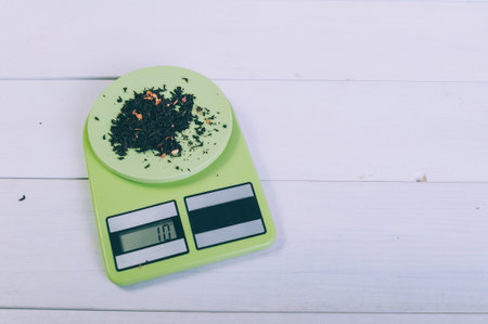 Loose tea on a kitchen scale on a wooden tableの写真素材
