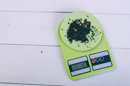Loose tea on a kitchen scale on a wooden tableの写真素材