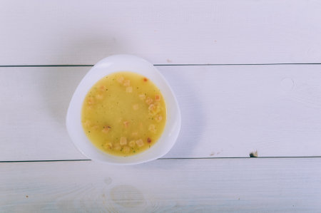 Broth soup in a bowl on a wooden tableの写真素材