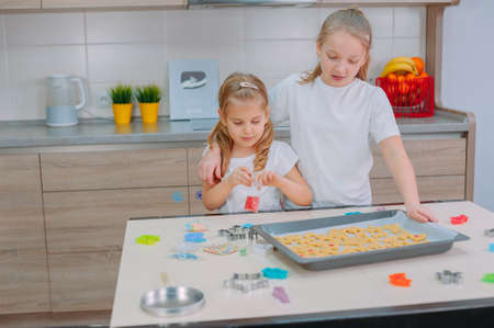 Two sisters are making homemade cookies in the kitchenの写真素材