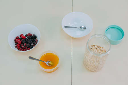 Oatmeal with fruit in a glass on a table with honeyの写真素材