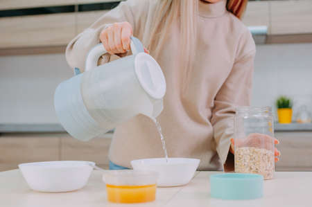 Mom prepares oatmeal with honey in the kitchenの写真素材