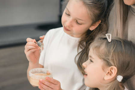 Two sisters bloggers cook in the kitchen and shoot a culinary video on a smartphone
