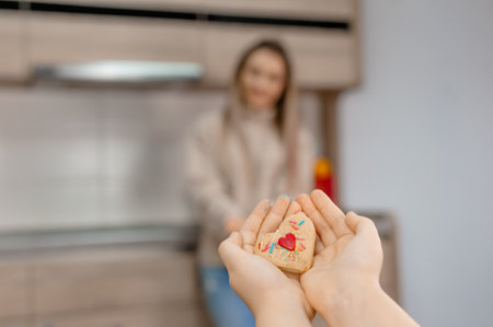 The daughter gives her mom a cookie with a red heart