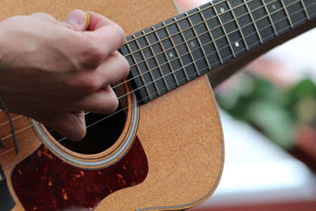Hand strumming a guitar