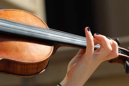Close up of a female busker hand playing a violinの写真素材