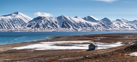 Svalbard mountain range with a lonely house at the foregroundの写真素材