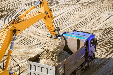 Work of the excavator at quarry. Loading sand into a dump truck.の写真素材