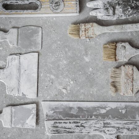 Plastering tools on cement background. View from top. Square location.