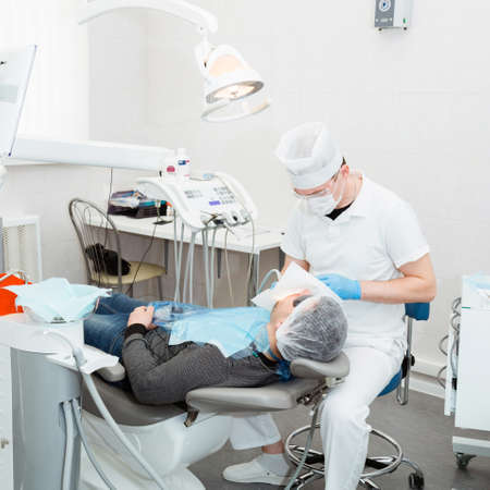 Dentist doctor treats the teeth to the patient.の写真素材