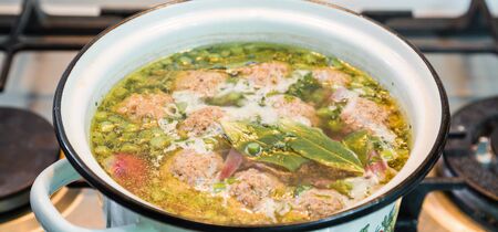 Homemade soup with meatballs in a saucepan. Closeup.の写真素材